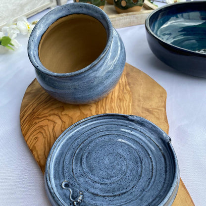 handmade salt pig and spoon rest on a wooden platter